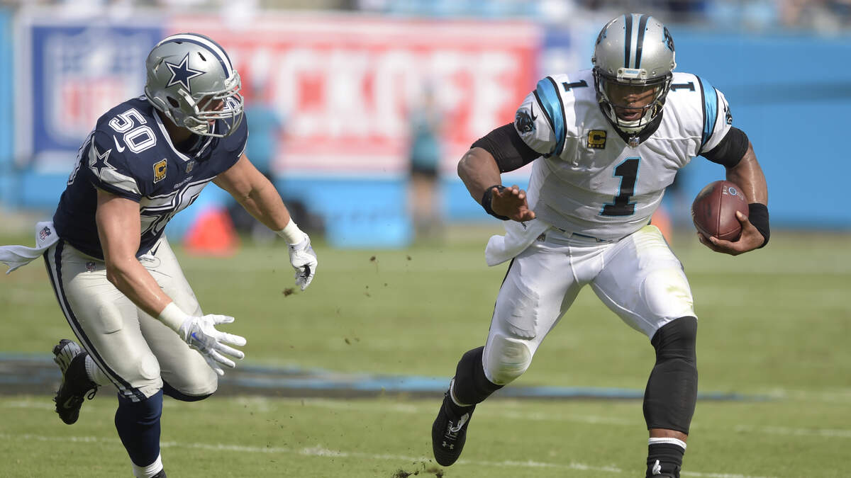 Panthers’ Cam Newton runs past Cowboys’ linebacker Sean Lee in the first half at Bank of America Stadium in Charlotte, N.C., on Sunday. The Panthers defeated the Cowboys 16-8.