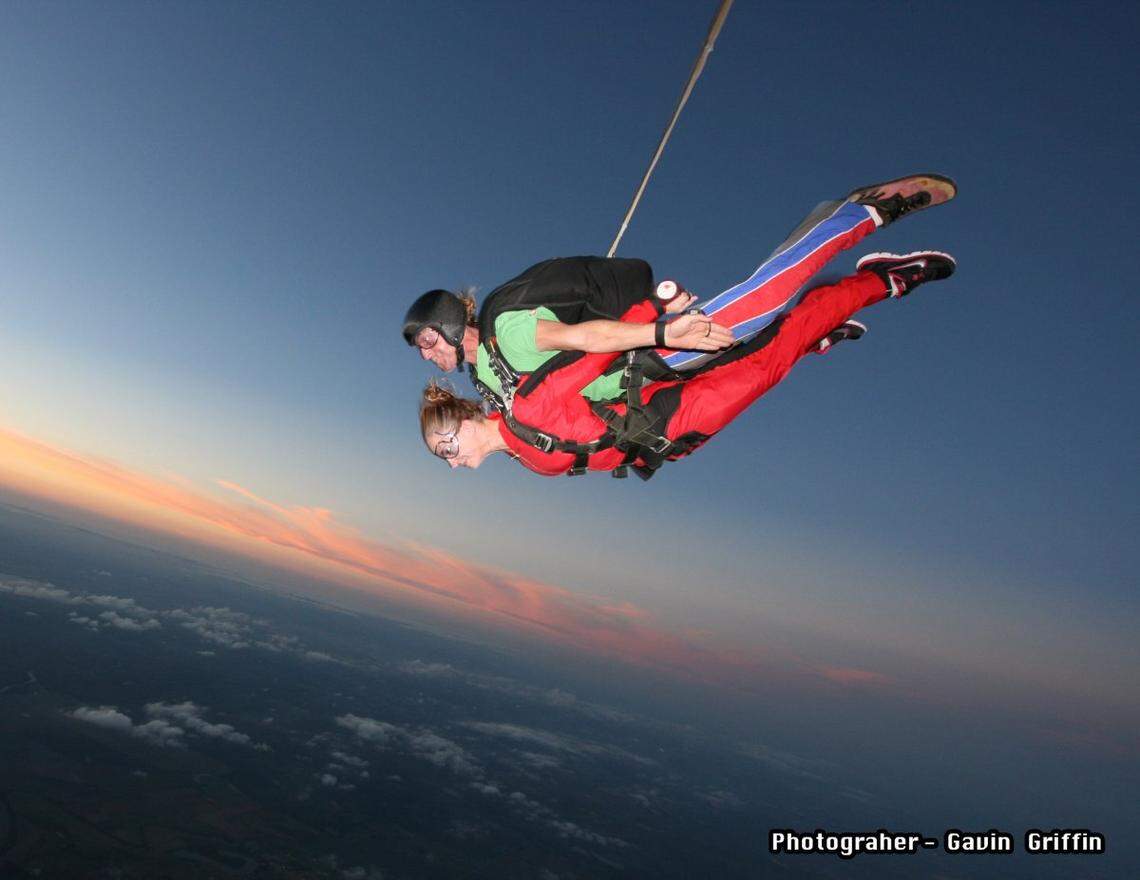 This tandem pair is in the initial free fall stage of a skydive.
