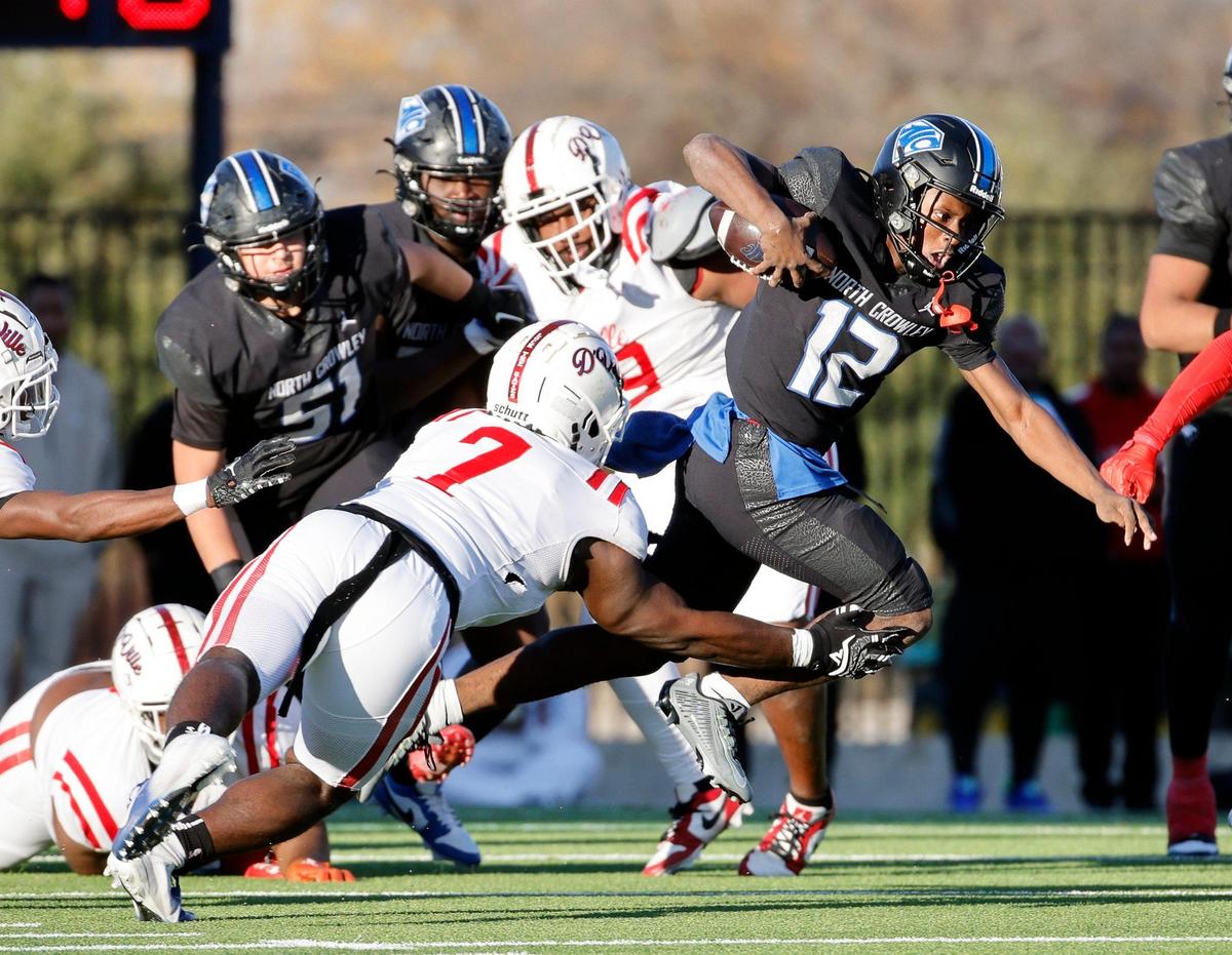 North Crowley quarterback Chris Jimerson (12) gains a couple of yards during the first half of a UIL Conference 6A Division I state semifinal football playoff game at Mesquite Memorial Stadium in Mesquite, Texas, Saturday, Dec. 09, 2023. Duncanville led North Crowley 24-0 at the half.