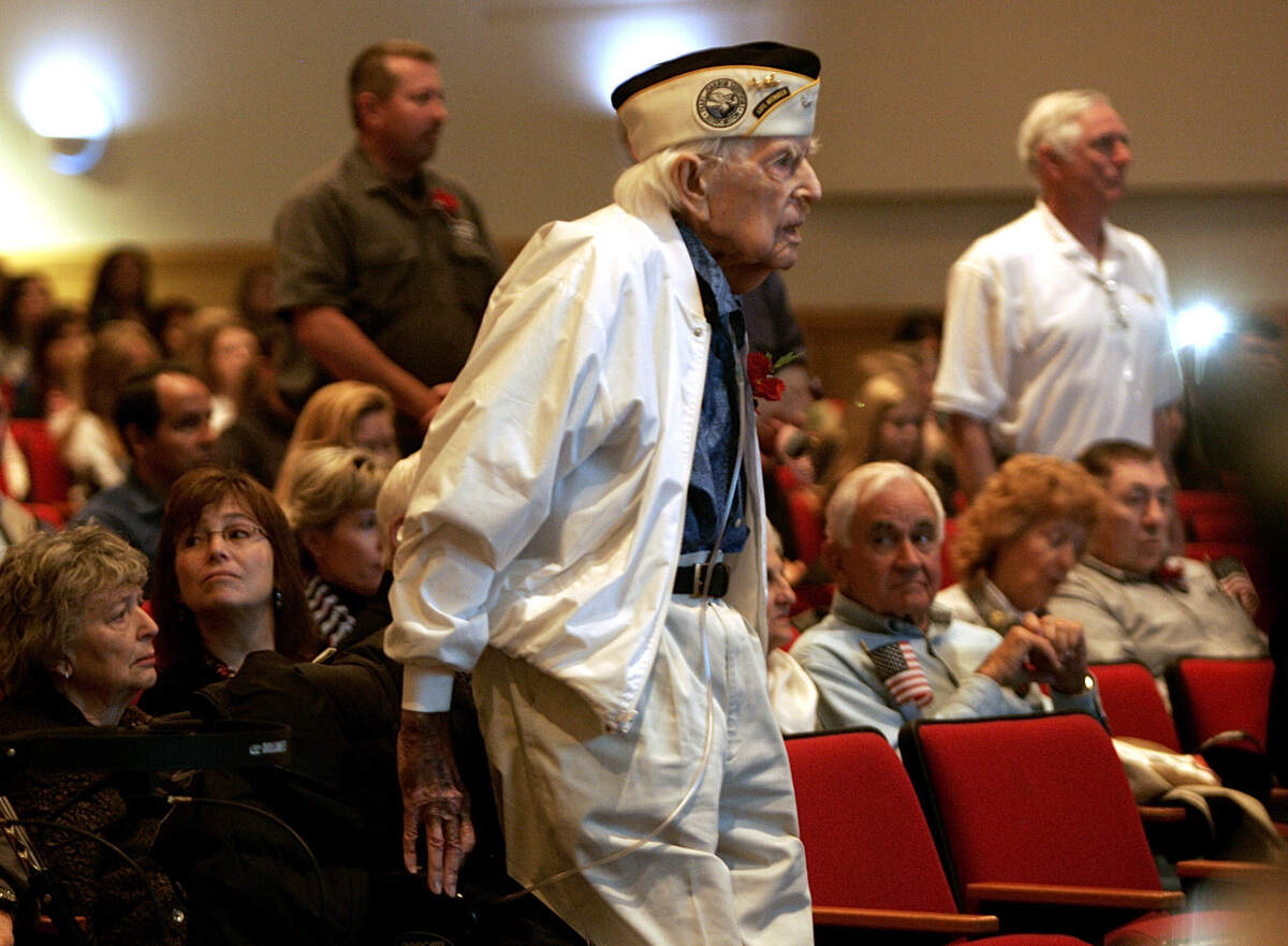 Nov. 11, 2014: A Pearl Harbor survivor, Navy aviator Charles Peters stands with other veterans as “Anchors Aweigh” is played by the school band during a Veterans Day celebration at Grapevine High School. The program to honor veterans also included a brunch and dedicating of the WWI memorial stone in the schools Veterans Park.