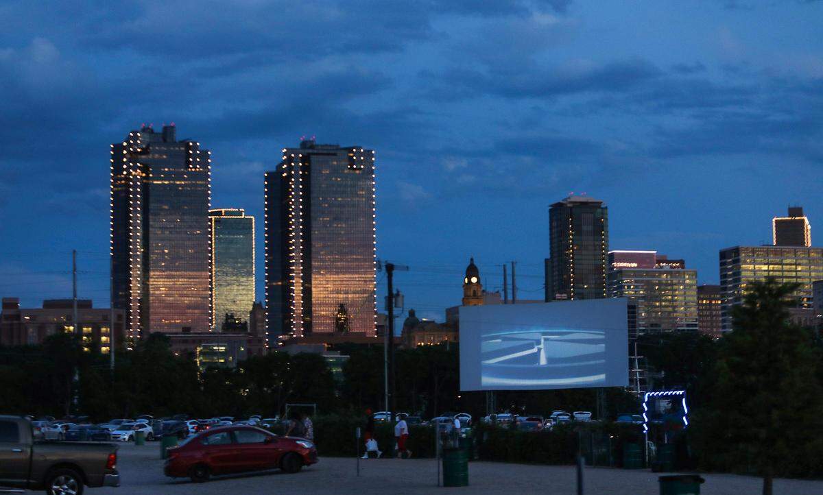 The sun sets as a movie begins at one of four screens at Coyote Drive-In movie theater on Wednesday, May 27, 2020, in Fort Worth. The drive-in initially closed during the coronavirus pandemic, but opened at limited capacity when the state began reopening in May. Chris Fortune, director of operations at the drive-in, said they have sold out every night.