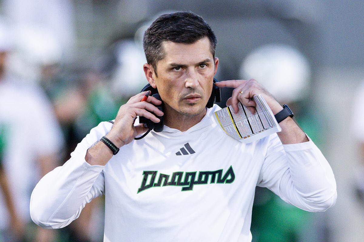 Southlake Head Coach Riley Dodge puts on his headset in the first half of an high school game between Southlake Carroll and Euless-Trinity at Dragon Stadium in Southlake on Friday, Sept. 19, 2025.