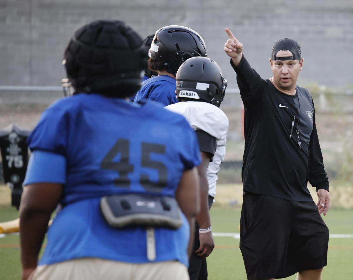 North Crowley offensive coordinator Kevin Parks works with the linemen during their first practice Thursday.