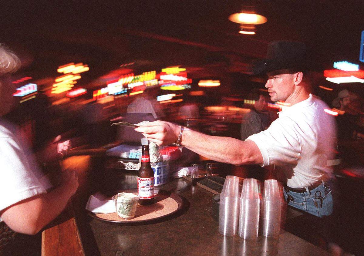 Aug. 28, 1999: Head bartender Russell Stuart from Fort Worth hands change to a customer after serving a bottle of beer at Billy Bob’s Texas