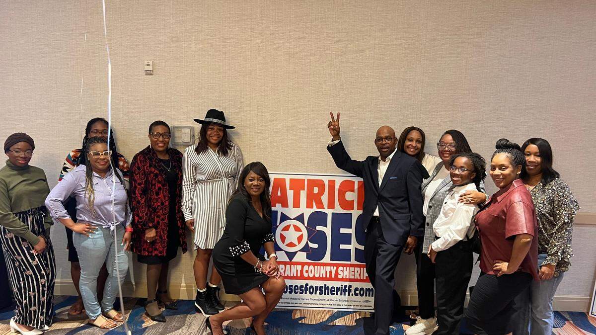 Patrick Moses posses with supporters at his watch party in Arlington