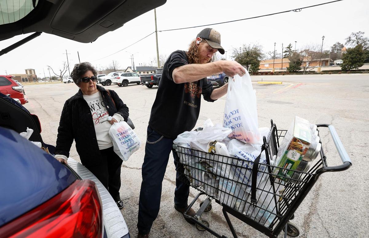 City Market employee Matt Nitzinger unloads customer Regena Morris’ groceries into her vehicle on Wednesday, Feb. 5, 2025. “We try to be the hometown store,” said owner Kurt Jaeger. “We take people’s groceries out.”