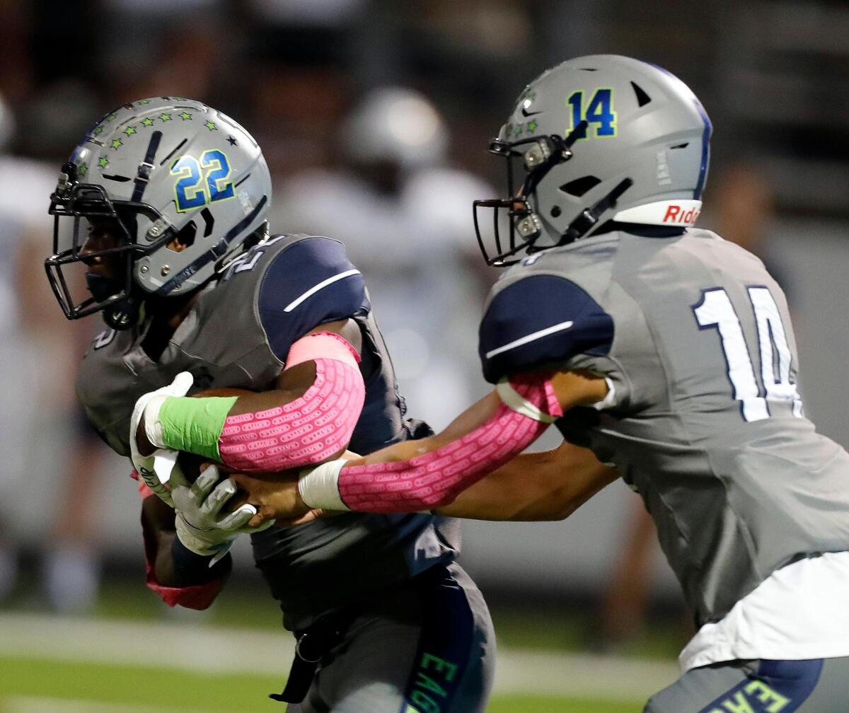 Eaton running back JB Brown (22) takes the hand off from quarterback Noah Lugo (14)in a high school district 4-6A football game at NWISD Stadium in Justin, Texas, Friday Oct. 08, 2021. Keller led Eaton 21-10 at the half. (Special to the Star-Telegram Bob Booth)