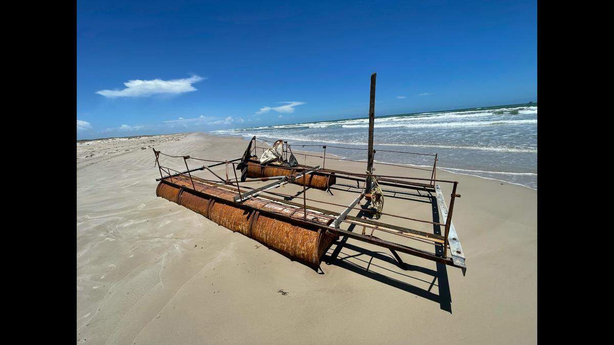 The makeshift raft has a broken tree branch for a mast.