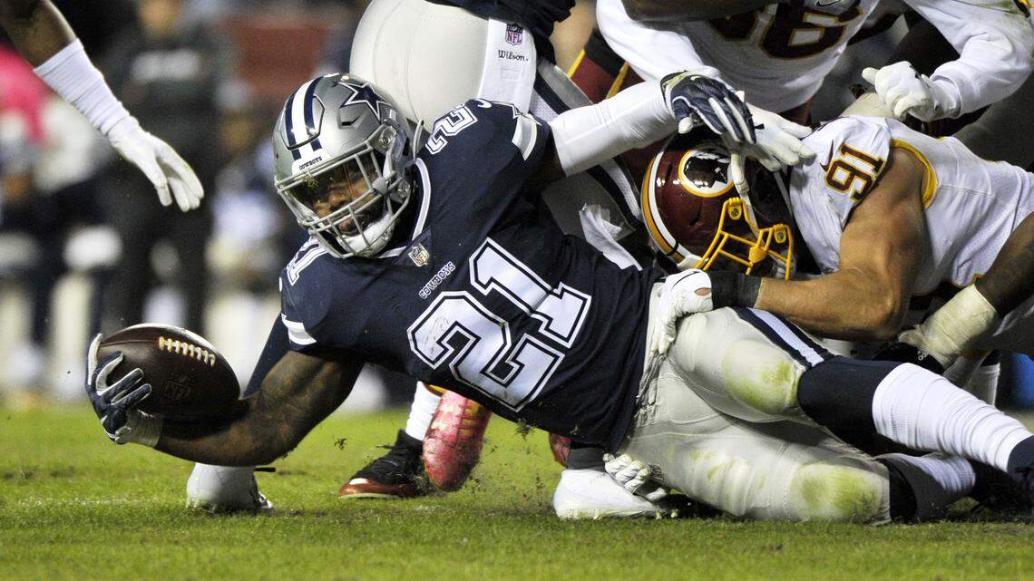 Dallas Cowboys running back Ezekiel Elliott (left) is tackled by Washington Redskins linebacker Ryan Kerrigan (right) during an NFL football game between the Dallas Cowboys and Washington Redskins, Sunday, Oct. 21, 2018, in Landover, Md.