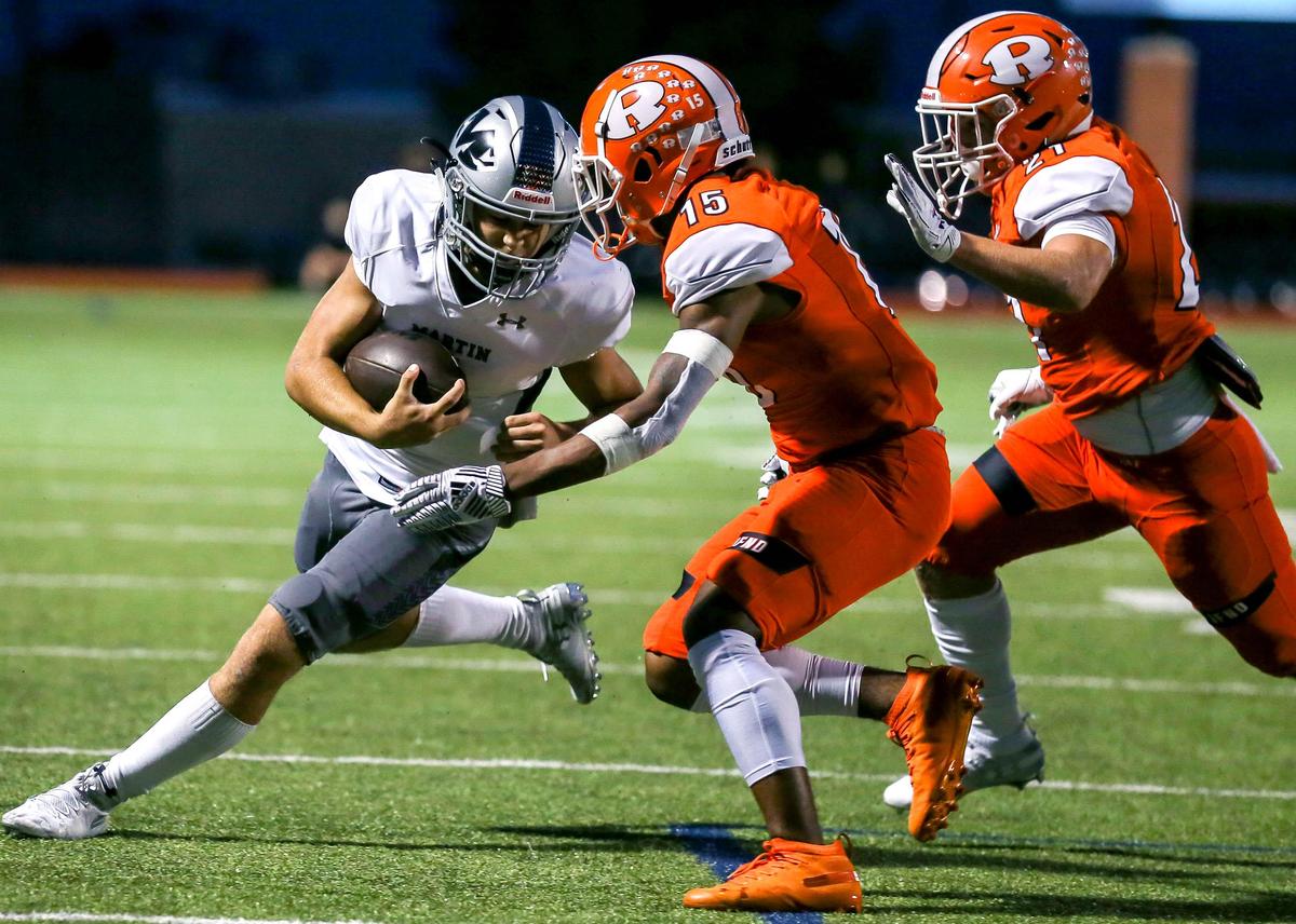 Arlington Martin quarterback Zach Mundell (L) lowers his head against Rockwall defensive back PJ Barber (15) and defensive back Drew Molck (21) during the first half, Friday night, September 20, 2019 played at Wilkerson-Sanders Stadium in Rockwall, TX