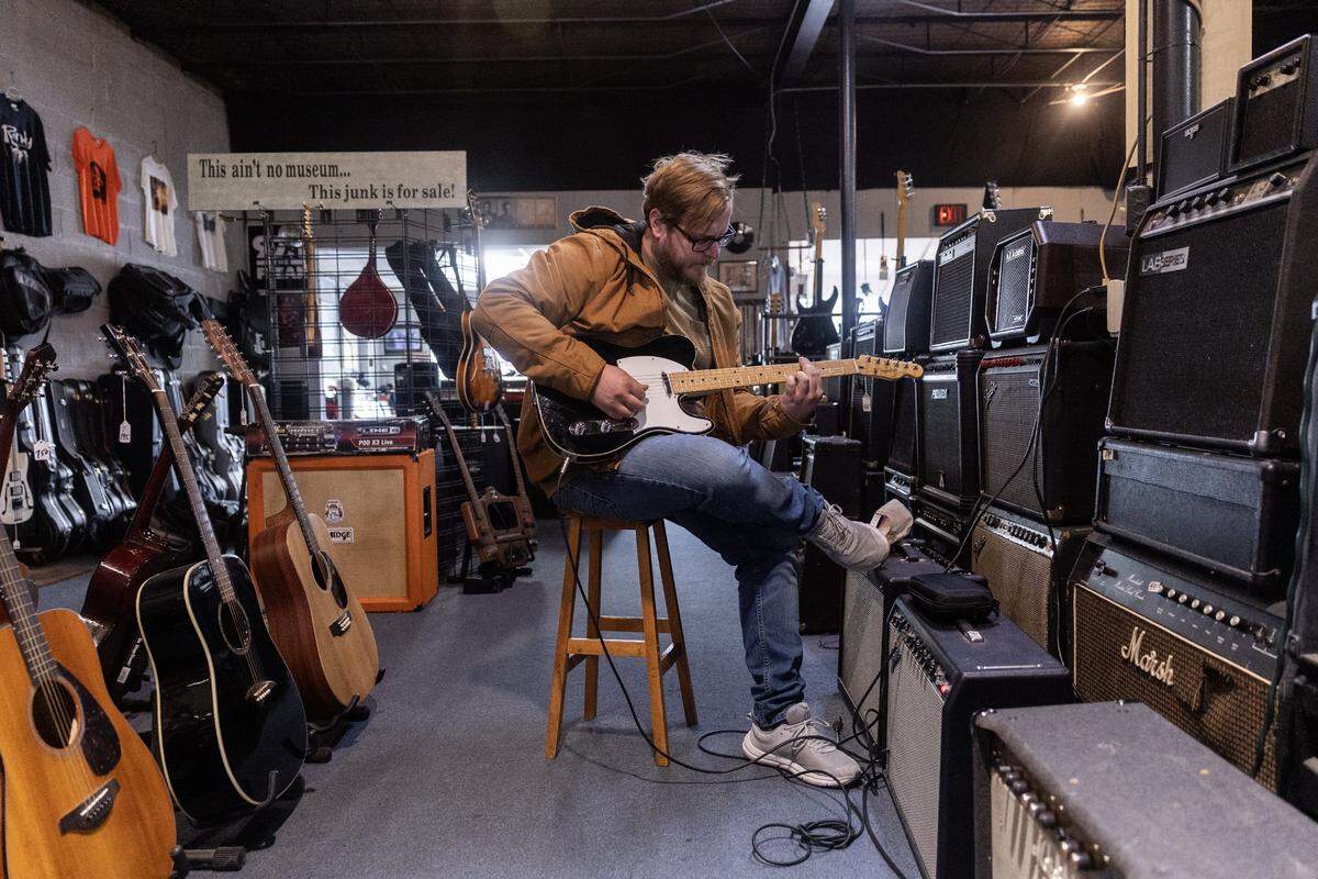 Dallas resident John Carter plays the bass guitar around the guitar area of the shop on East Lancaster Avenue in Fort Worth on Thursday, Sept. 4, 2025.