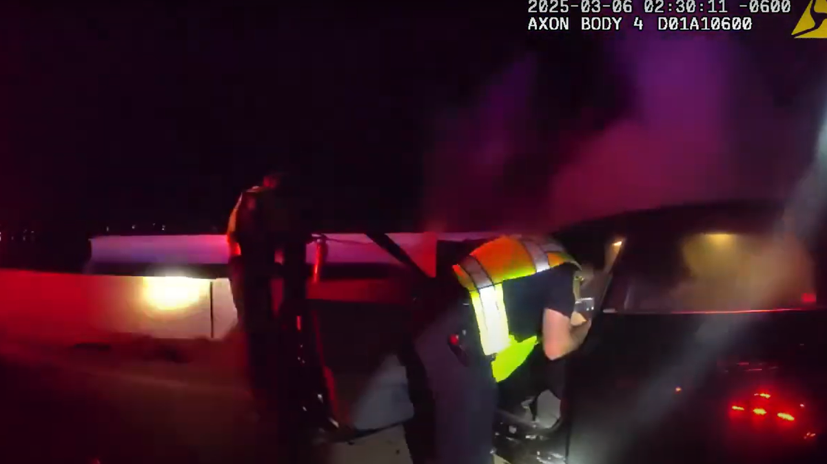 A frame from body camera footage shows a Rowlett police officer rescuing an intoxicated driver from his burning vehicle early Thursday March 6, 2025.