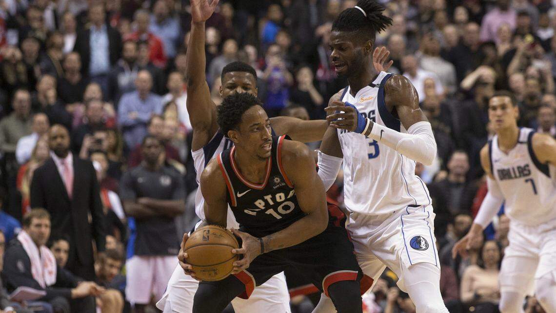Toronto Raptors guard DeMar DeRozan (10) shields the ball from Mavericks guard Dennis Smith Jr. (1) and center Nerlens Noel (3) during overtime Friday.