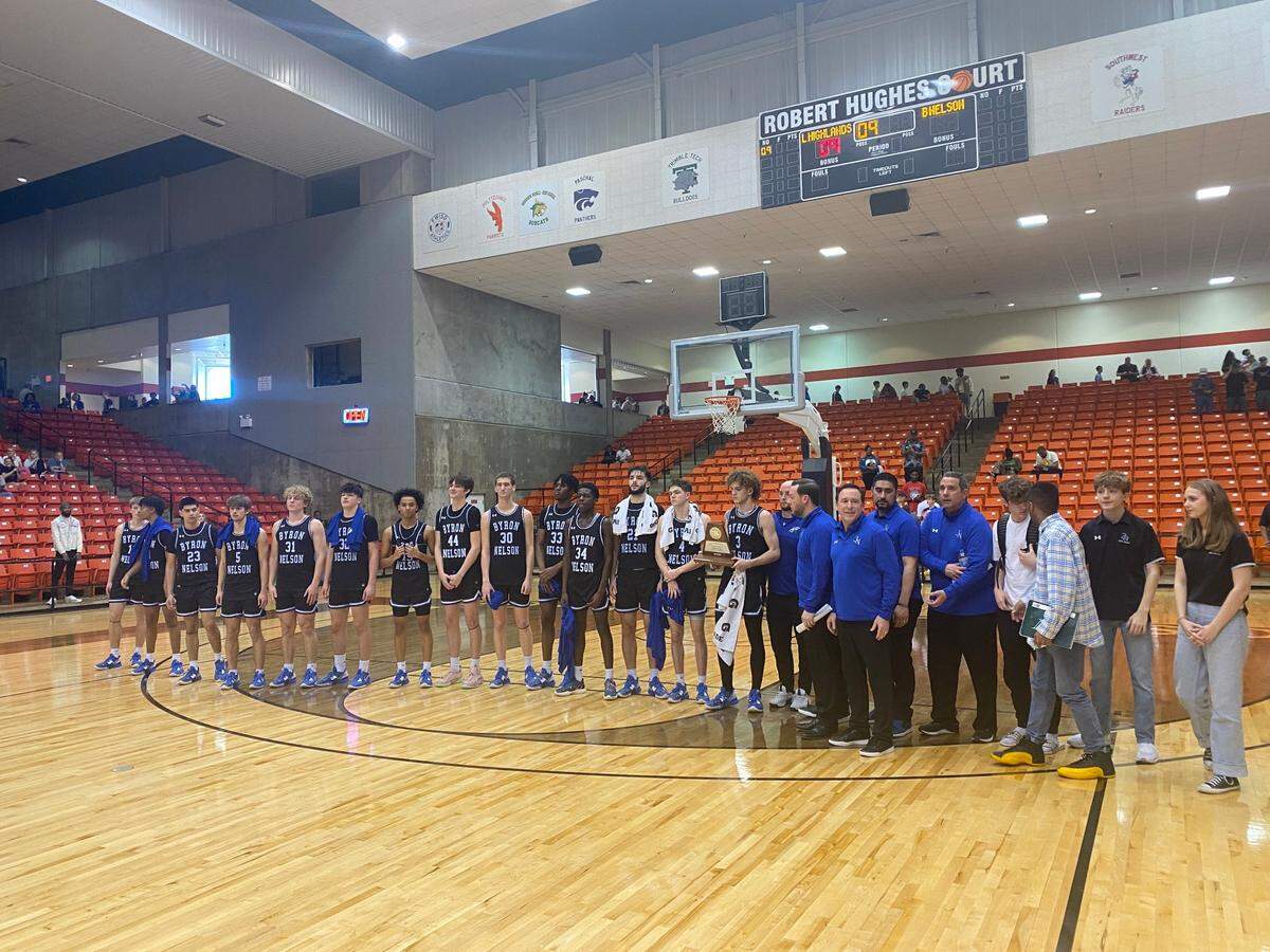 Byron Nelson holding the second place trophy after falling to Lake Highlands 62-36
