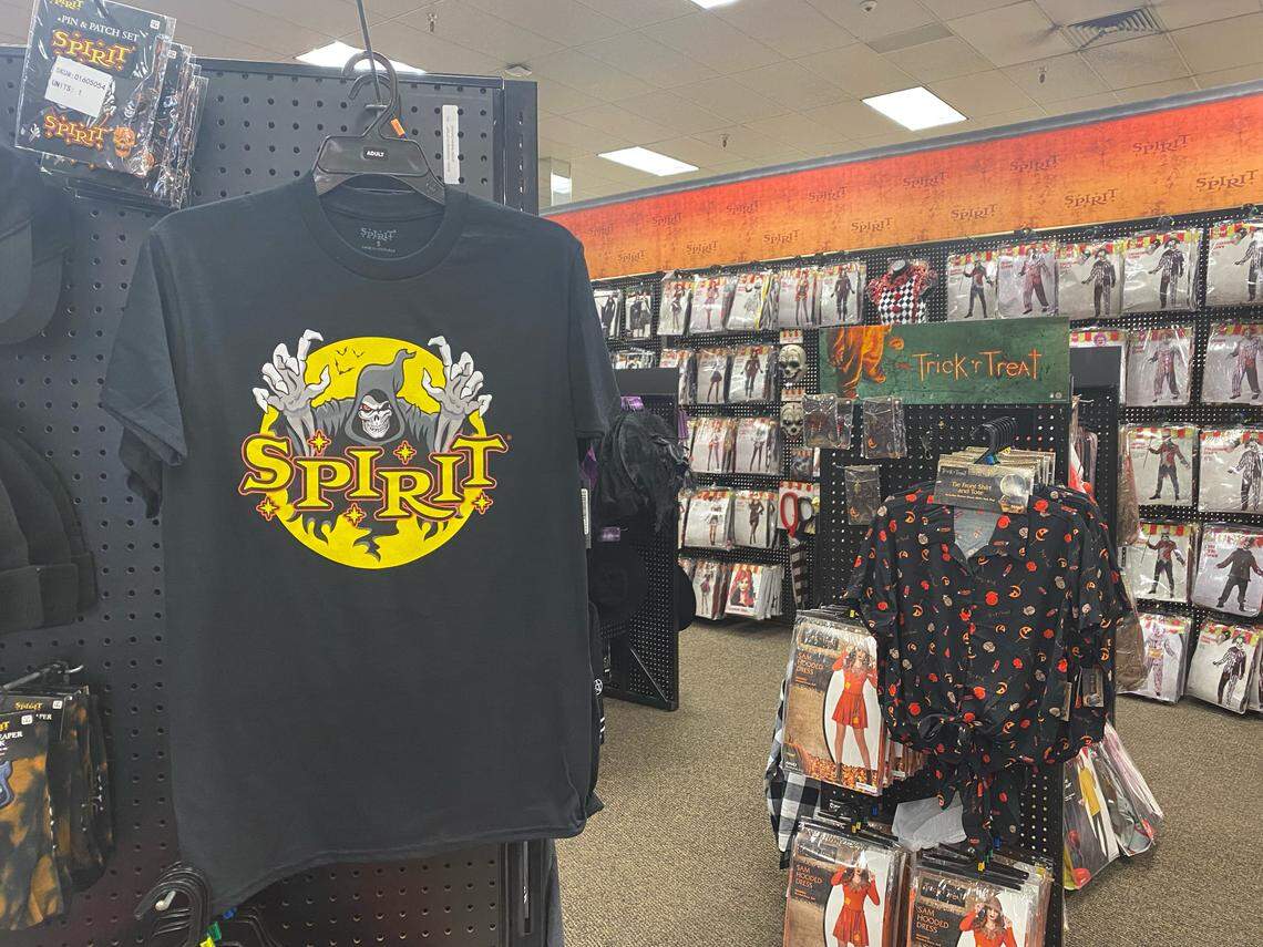 A picture of Spirit Halloween T-shirts and other costumes hanging across the Hulen store.