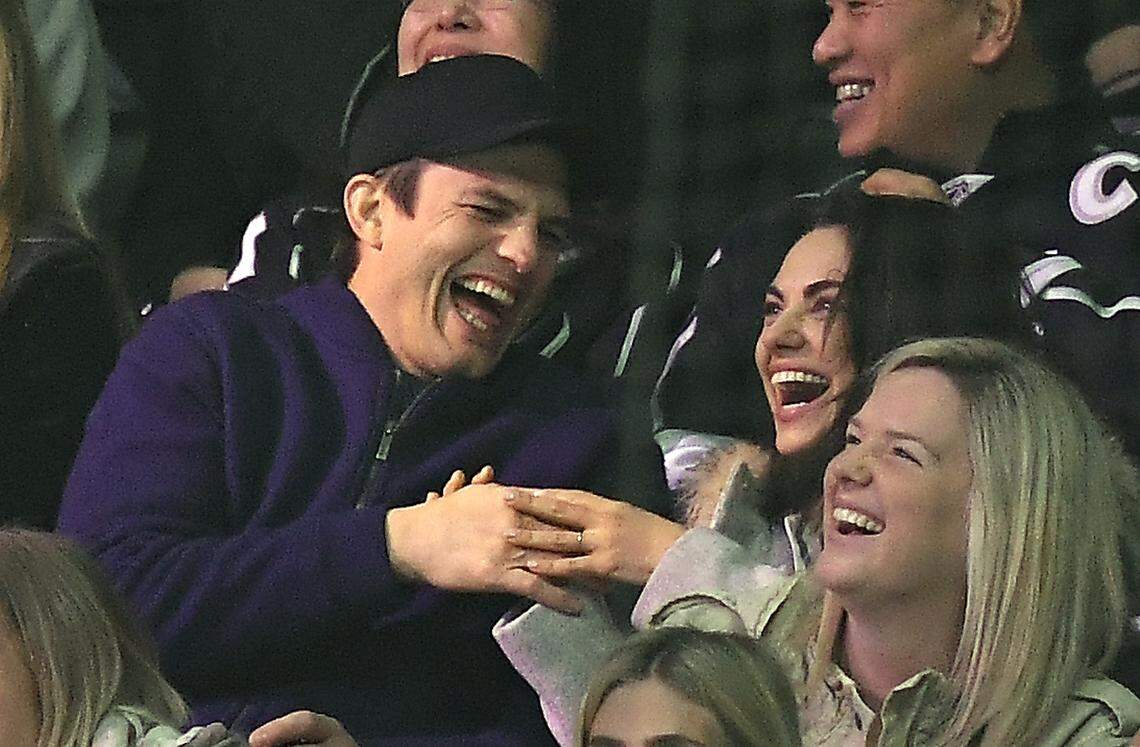 Actor Ashton Kutcher, left, and actress Mila Kunis laugh after kissing on camera as the crowd cheers during the third period of an NHL hockey game between the Los Angeles Kings and the Vegas Golden Knights, Monday, Feb. 26, 2018, in Los Angeles. (AP Photo/Mark J. Terrill)