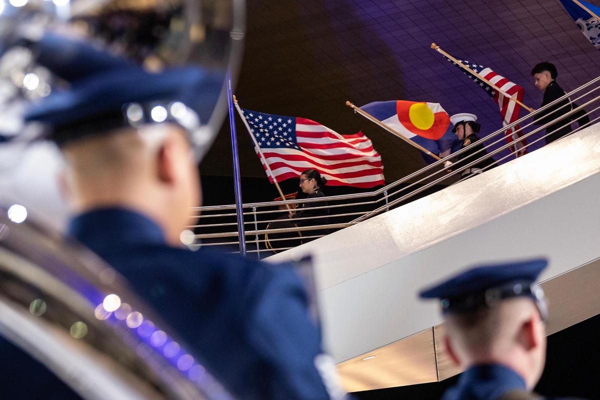 Members of the military carry the United States flag and individual state flags down the stairs as the U.S. Air Force Ceremonial Band performs during the ribbon cutting ceremony for the National Medal of Honor Museum Grand Opening Celebration in the Arlington Entertainment District on Saturday, March 22, 2025.