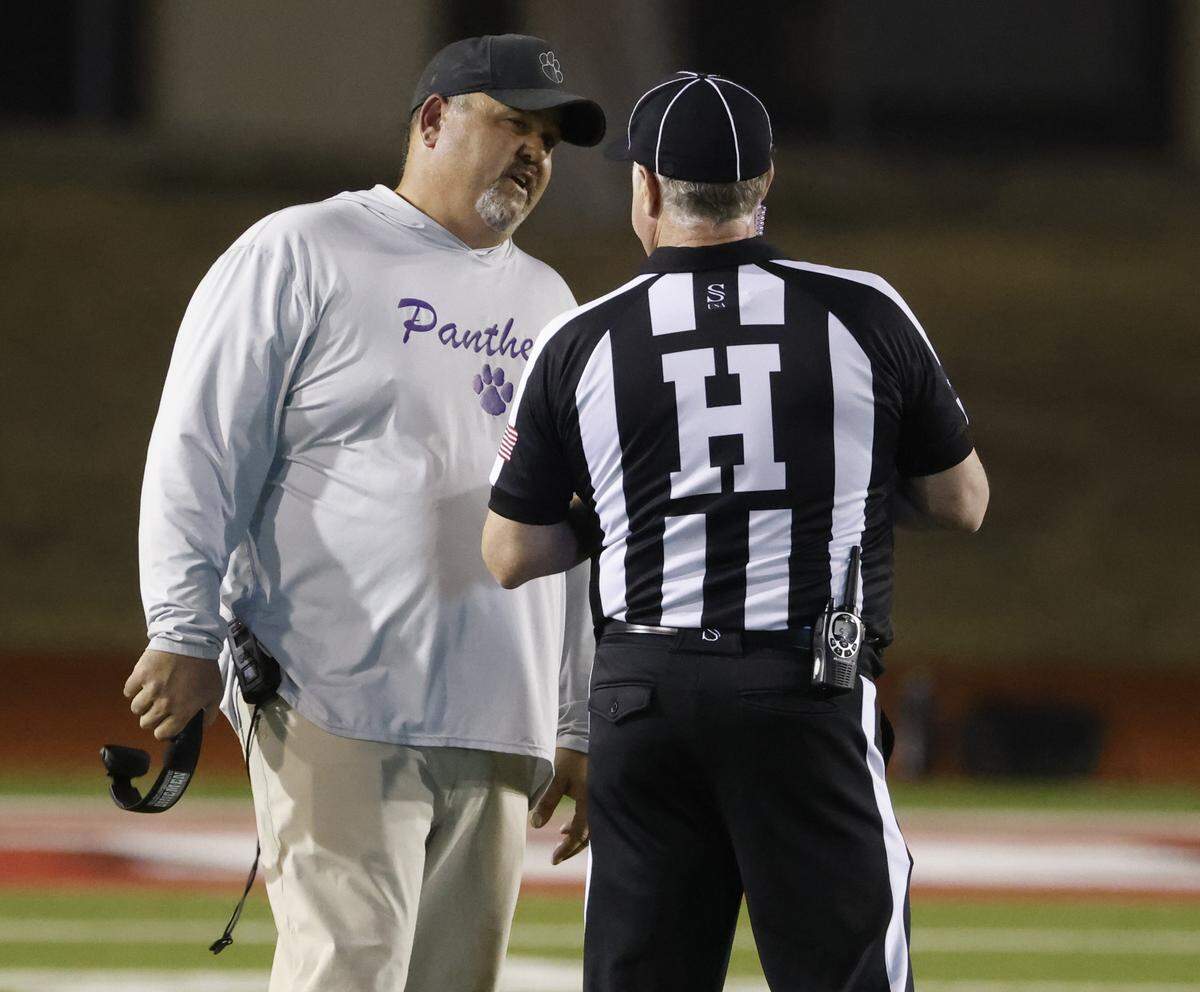 Paschal head coach John Killough talks with head linesman Scott Brock during the first half of a UIL football game between Saginaw and Paschal at Farrington Field in Fort Worth, Texas, Thursday, October, 16, 2025.