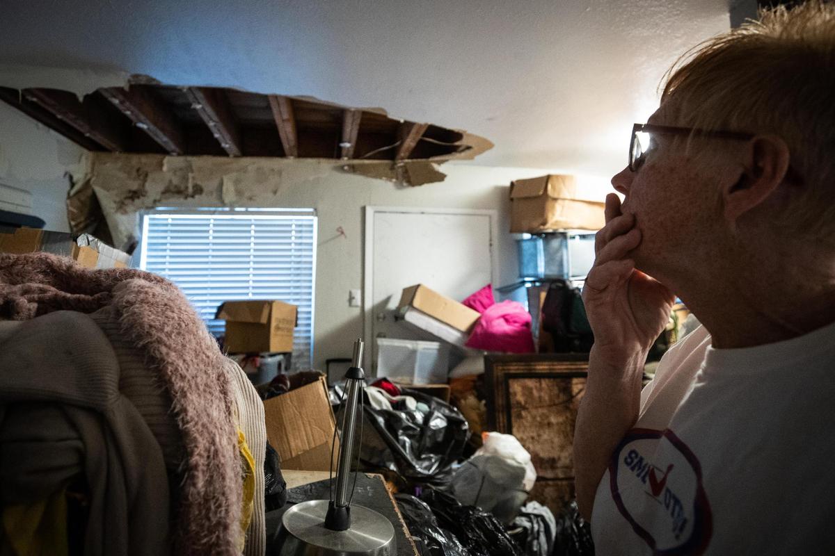 Carla Holland looks at damage on the ceiling in her apartment she shares with Colton Gregg Oct. 14, 2021, in Farmers Branch, a suburb of Dallas.