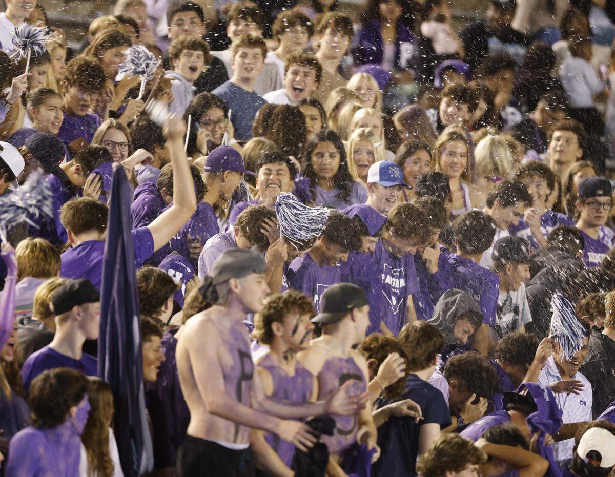 Paschal fans toss water during the first half of a UIL football game between Arlington Heights and Paschal at Farrington Field in Fort Worth, Texas, Friday Nov. 07, 2025.