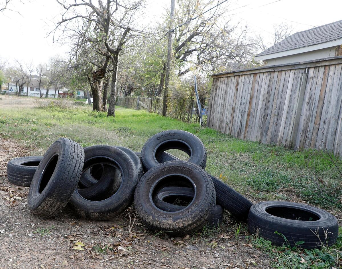 Several used tires are piled up in an empty lot Wednesday in the Historic Marine neighborhood in Fort Worth.