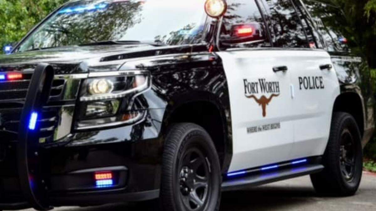 Black and white Fort Worth police SUV with red and blue police lights turned on.
