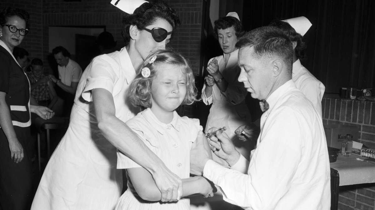 Dr. Frank Wallace administers the Salk polio vaccine to Barbara Ellen Watson, a fourth-grader at West Side Elementary in Arlington. Tarrant County began a mass polio vaccination drive in April of 1955.