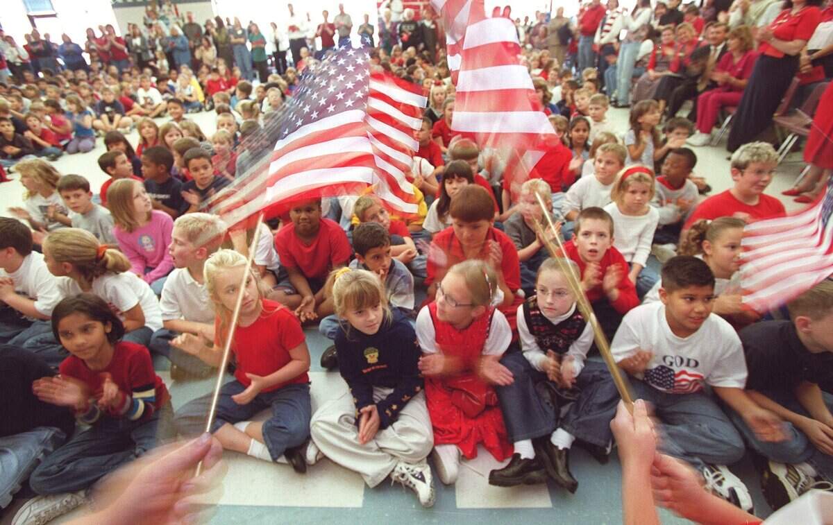 Nov. 9, 2001: Students watch a flag march around the gym during the singing of the National Anthem during the Veterans Day Program at North Ridge Elementary School in North Richland Hills.
