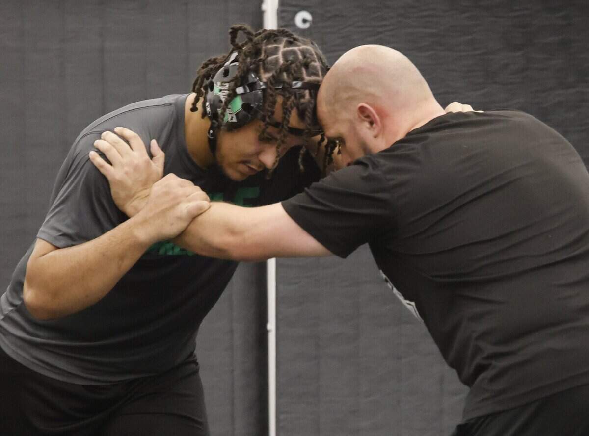Azle assistant wrestling coach Michael Mitchell works with Jordan Durrett during one of the final practices before the state championship meet at Azle High School in Azle, Texas, on Friday, Feb. 9, 2026.