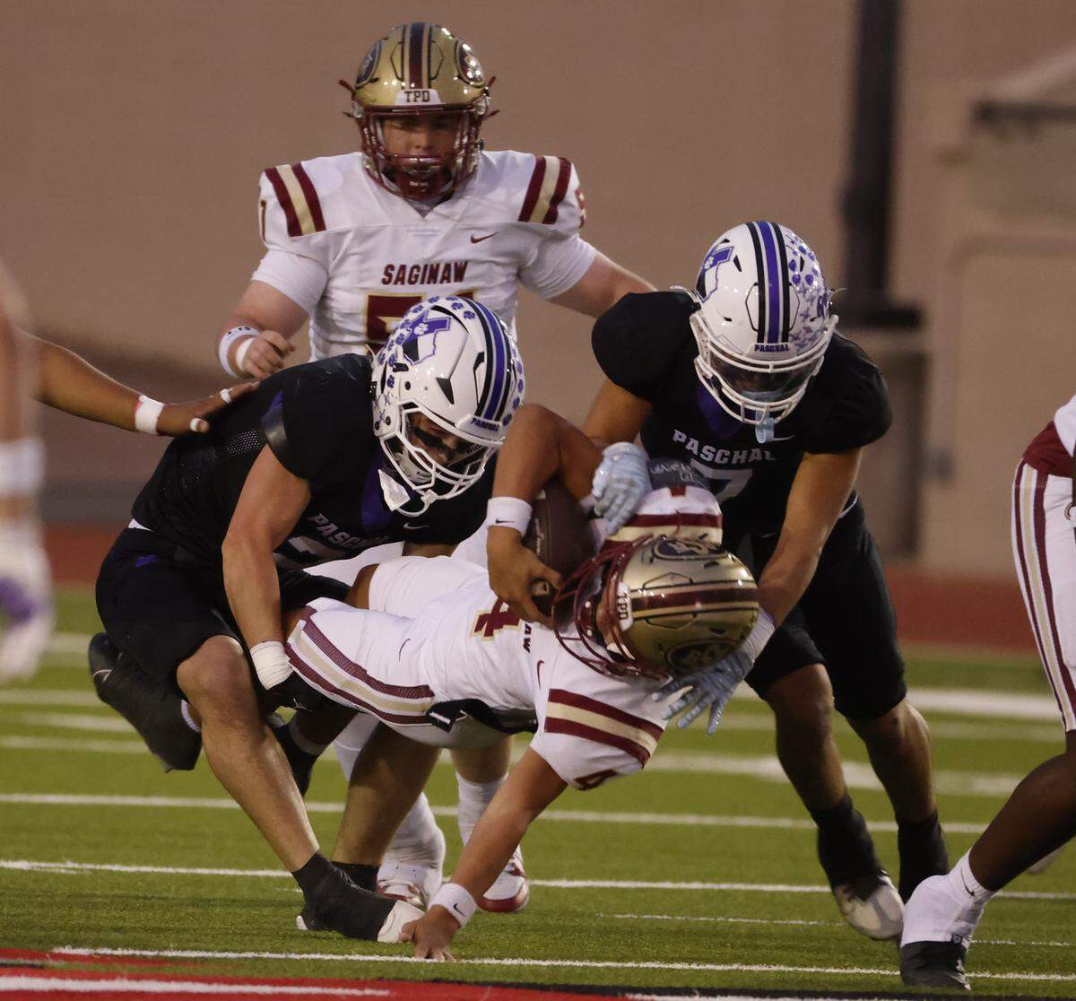 Saginaw running back Elijah Irvin (4) is brought down at the line of scrimmage during the first half of a UIL football game between Saginaw and Paschal at Farrington Field in Fort Worth, Texas, Thursday, October, 16, 2025.