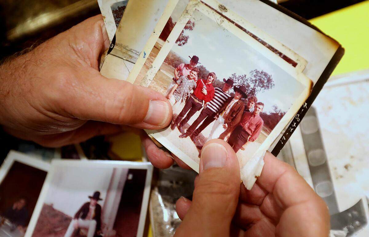 Reed Pigman shuffles through polaroids of the Beatles. Pigman was 14 years old when the Beatles visited his family’s ranch in Arkansas for a weekend during their 1964 U.S. tour.