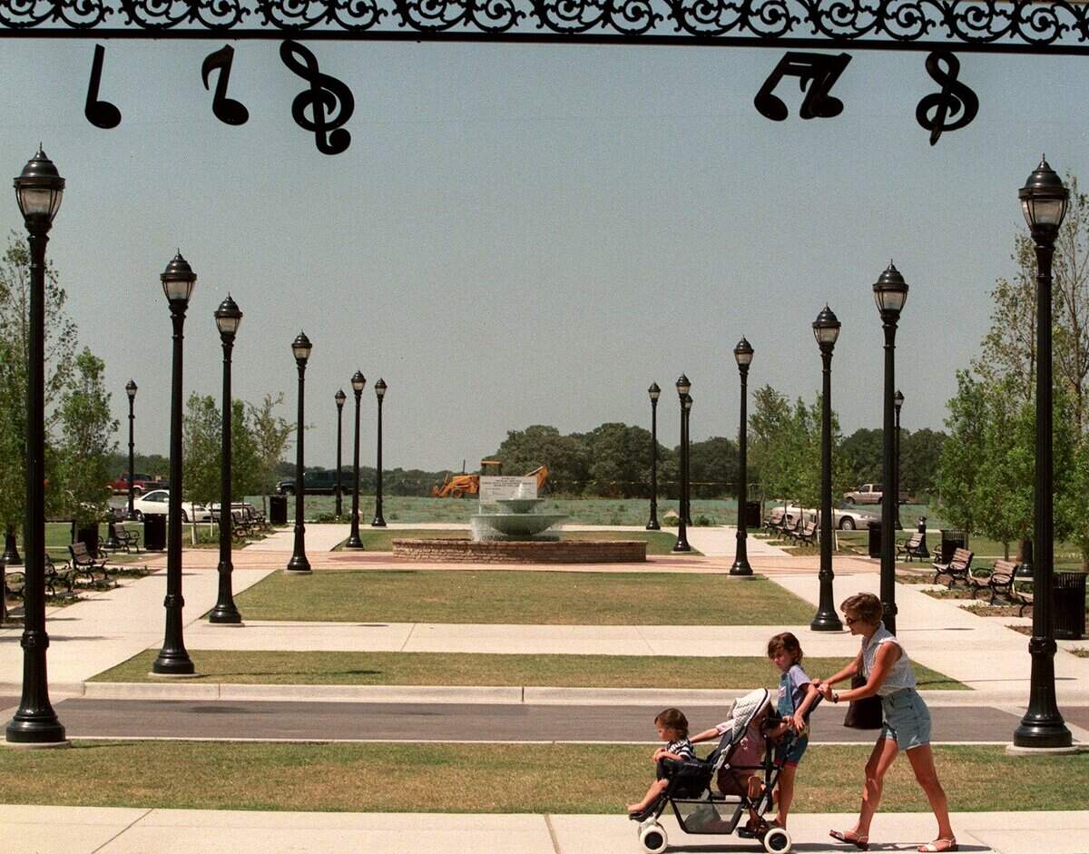 July 15, 1999: Amy Carroll of Southlake walks her children, 15-months-old Madeline, 5-year-old Erin and 6-year-old Katherine, through Southlake Town Square.