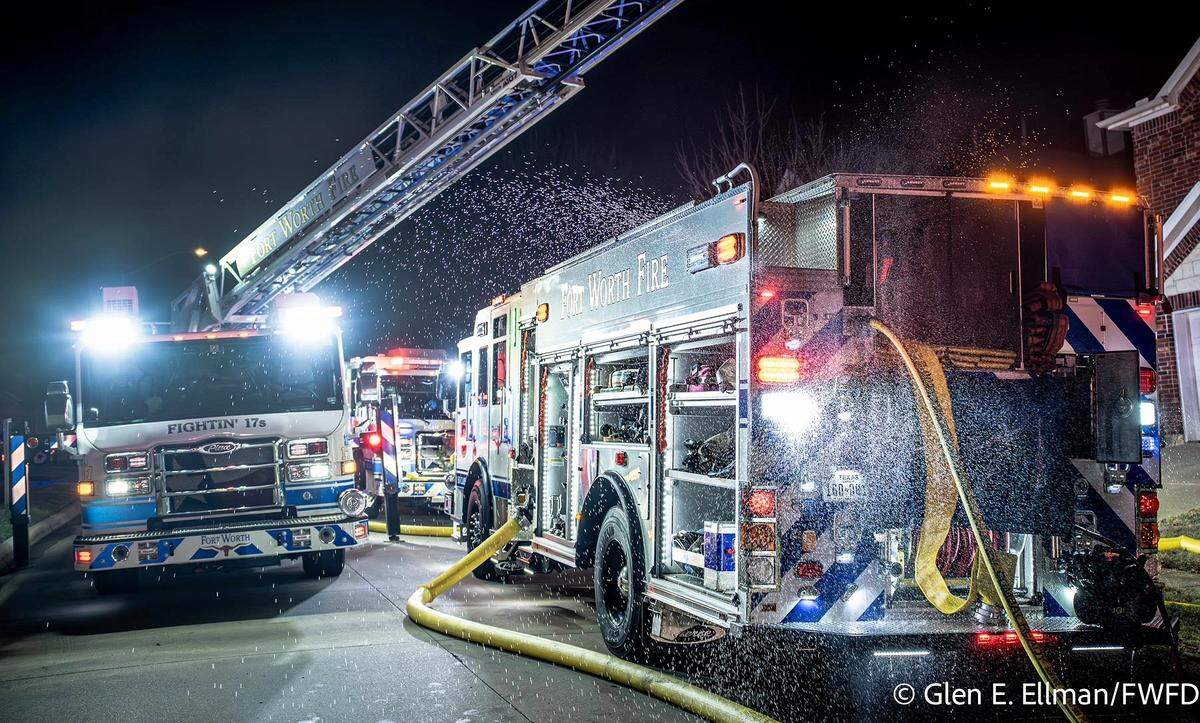 Fort Worth fire trucks work the scene of a house fire on Tuesday, Dec. 2, 2025.