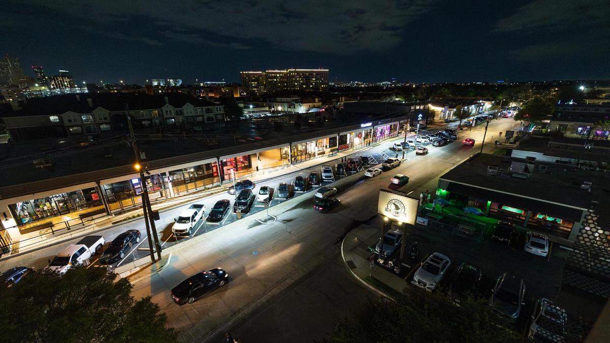 A strip of night clubs at night. 
