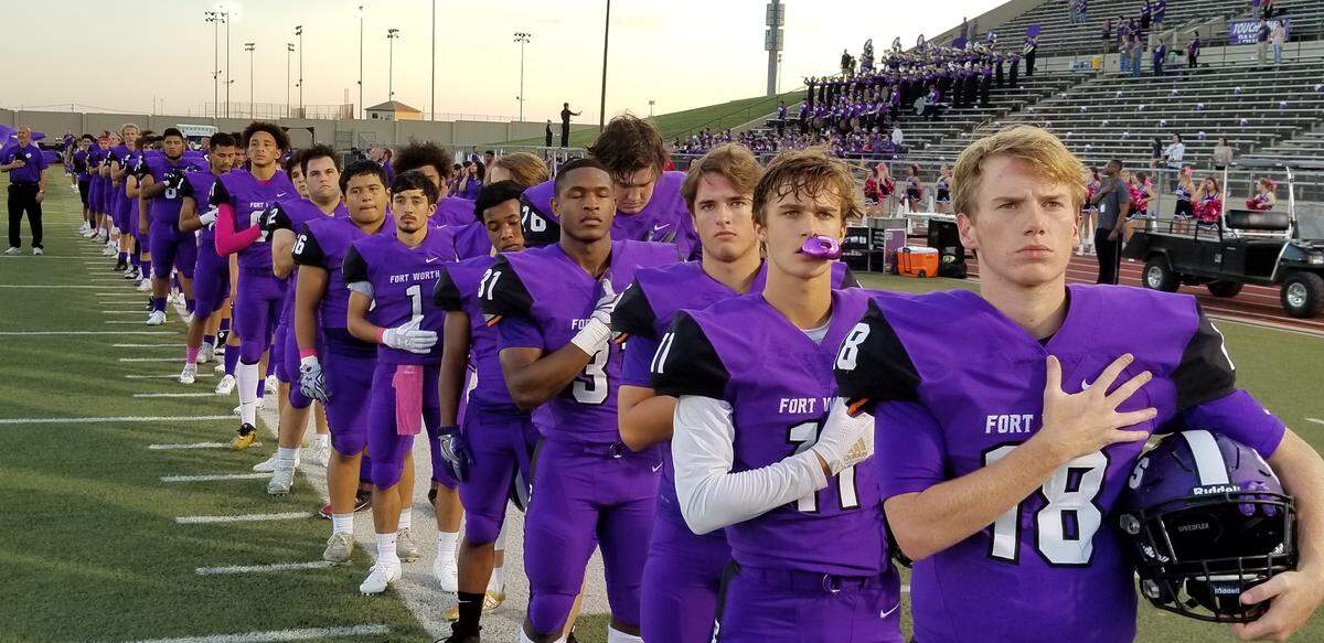 Paschal Panthers players prepare for Thursday night’s game against Arlington during the national anthem.