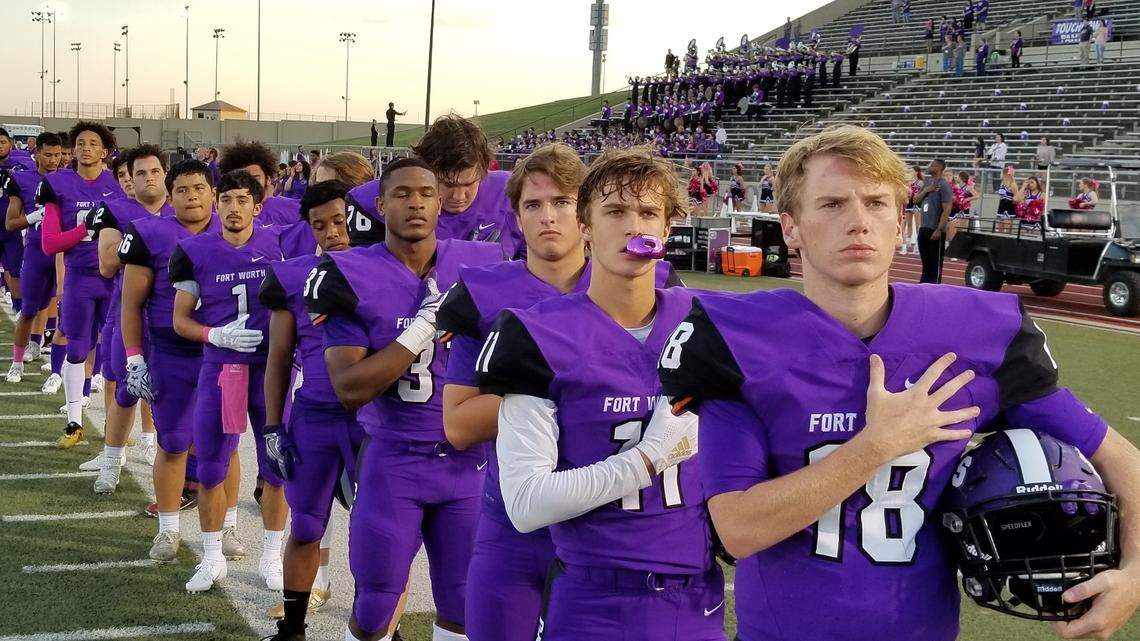 Paschal Panthers players prepare for Thursday night’s game against Arlington during the national anthem.