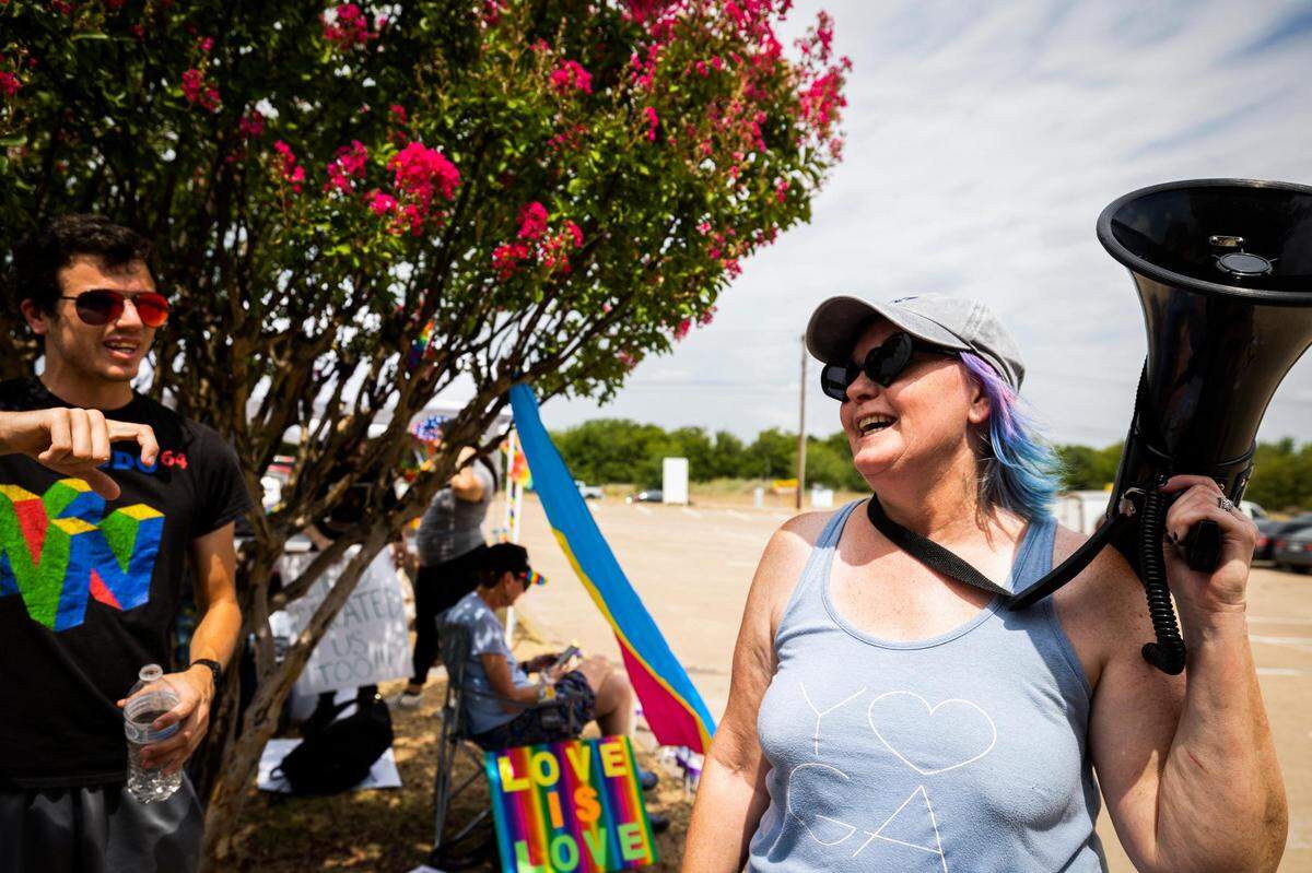 Lynette Sharp of Watauga chats with others during the protest against Stedfast Baptist Church July 3, 2022, in Watauga. Protesters set up tents with water and snacks to help with being outside in the hot summer weather.