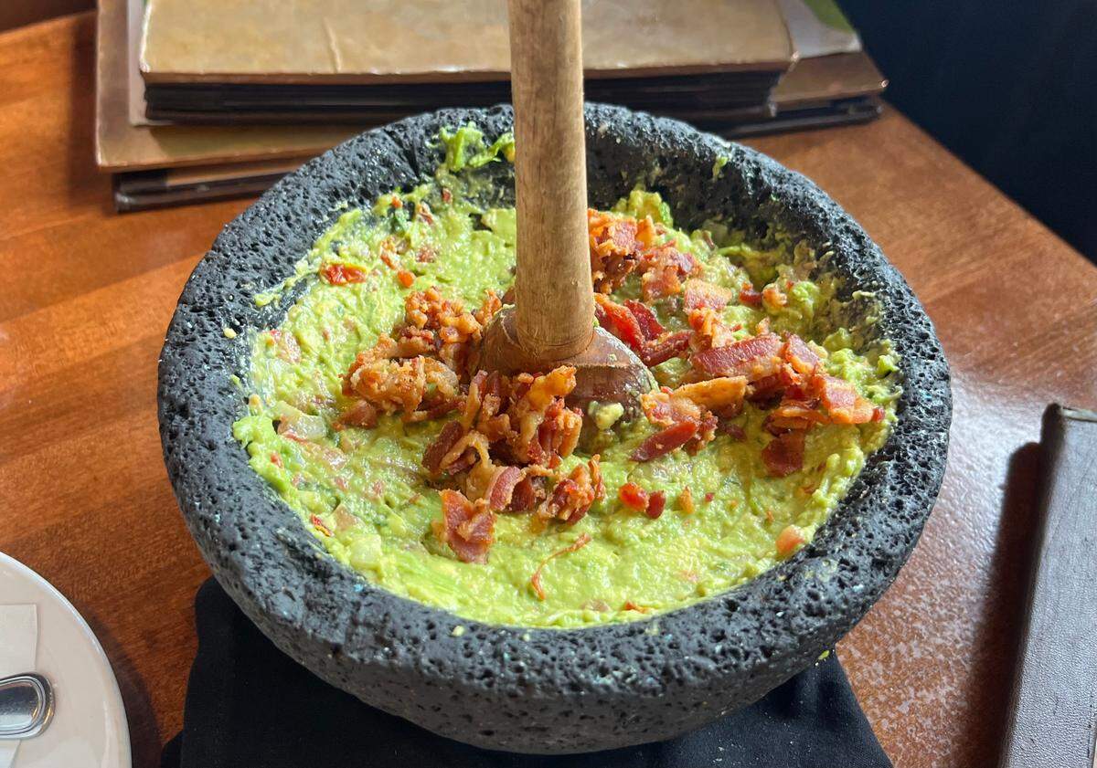A Mi Dia staple: table side guacamole, medium spice topped with crispy bacon. Bacon is an add on, but should be a permanent staple.