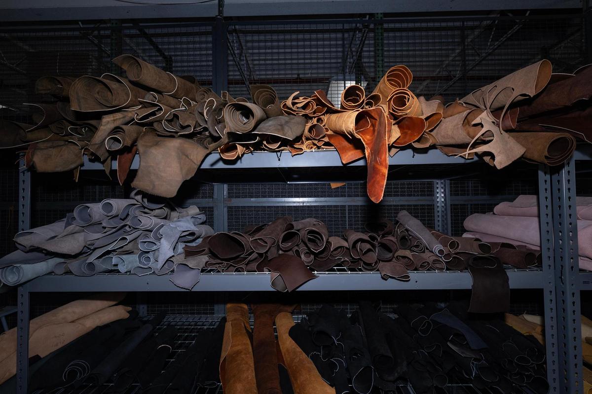 Different versions of the cowhydes are rolled and organized by color and thickness in the storage area of the factory.