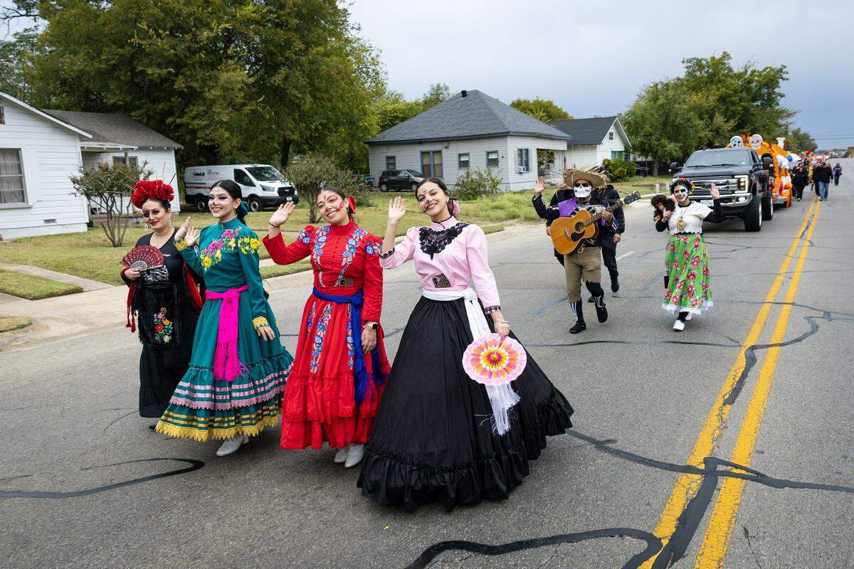 Parade participants from Ballet Folklorico Azteca de Fort Worth walk down Ellis Avenue for the Dia De Los Muertos Parade in Northside Fort Worth on Saturday, Nov. 1, 2025.