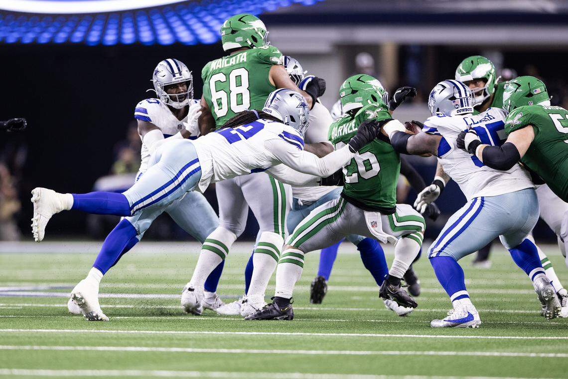 Cowboys defensive end Jadeveon Clowney (42) tackles Eagles running back Saquon Barkley from behind in the second half Sunday.