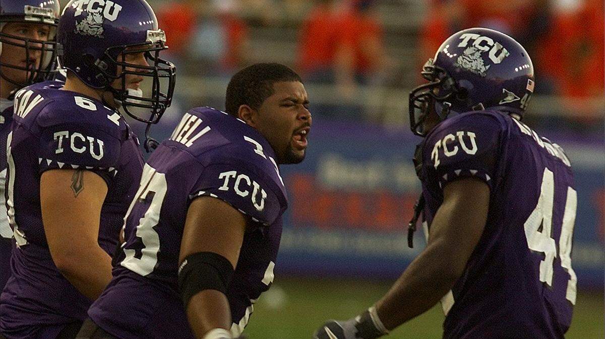 Former TCU offensive lineman Jamal Powell, center, congratulates LaMarcus MacDonald during a game against Tulane on Nov. 9, 2002, in Fort Worth. Powell, who had been serving as an assistant coach for SMU, died Tuesday at age 39. (Star-Telegram file photo/Sharon M. Steinman)