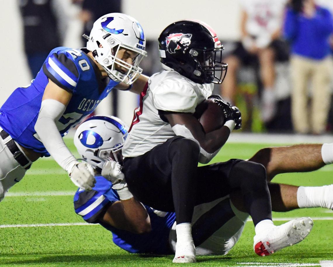 Decatur’s Brody McClure, left, and Brody Eddins tackle Wichita Falls’ Jordan Mitchell as runs for no gain in the first quarter of Friday’s December 2, 2022 4A Division 1 state quarterfinal football game at the Collins Athletic Complex in Denton, Texas. Special/Bob Haynes