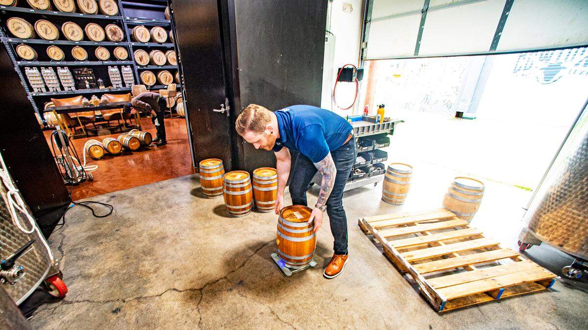 Chase Ament weighs a barrel before Aaron Hiler, lead distiller at Blackland Distillery, fills it up with bourbon for a test. Photo taken Monday, Feb. 6, 2023.
