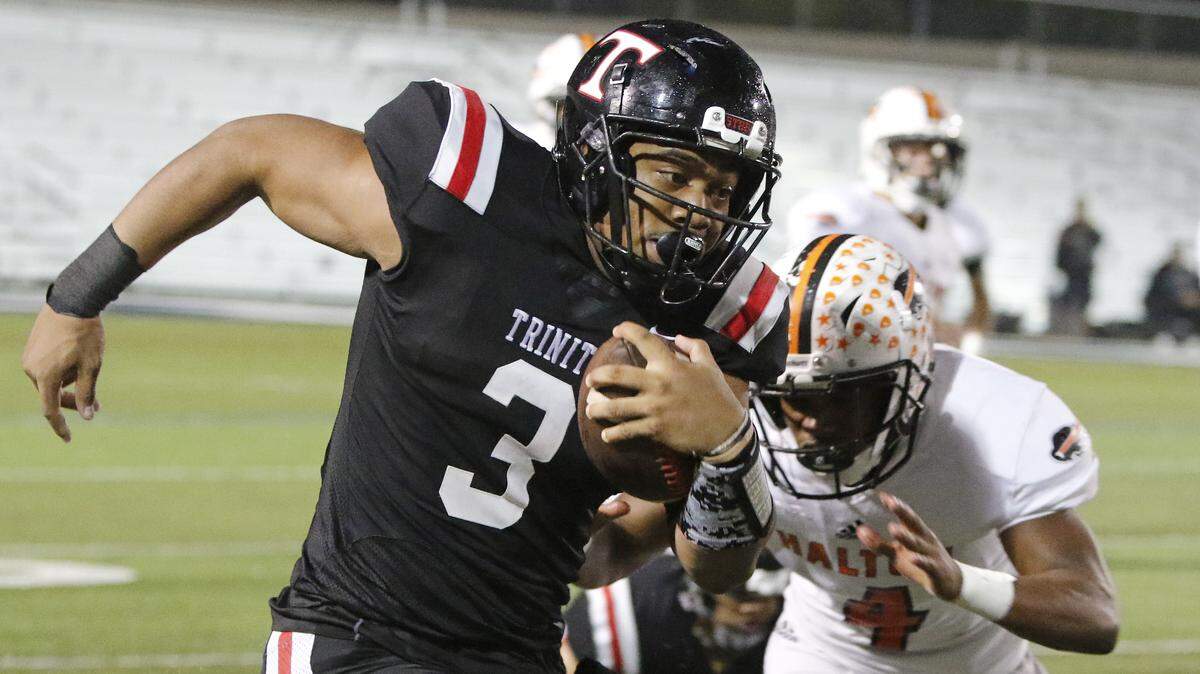 Trinity running back Brandon Theus (3) outruns the defense of Haltom defensive back Keyon Shannon (4) during the first half of a high school football game at Pennington Field in Bedford, Texas, Friday, Oct. 12, 2018. Haltom led 21-14 at the half. (Special to the Star-Telegram Bob Booth)

