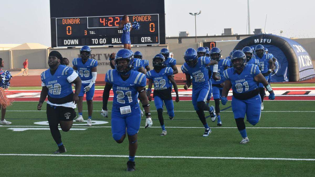 Fort Worth Dunbar takes the field during a high school football game against Ponder at Clark Stadium in Fort Worth, Texas.