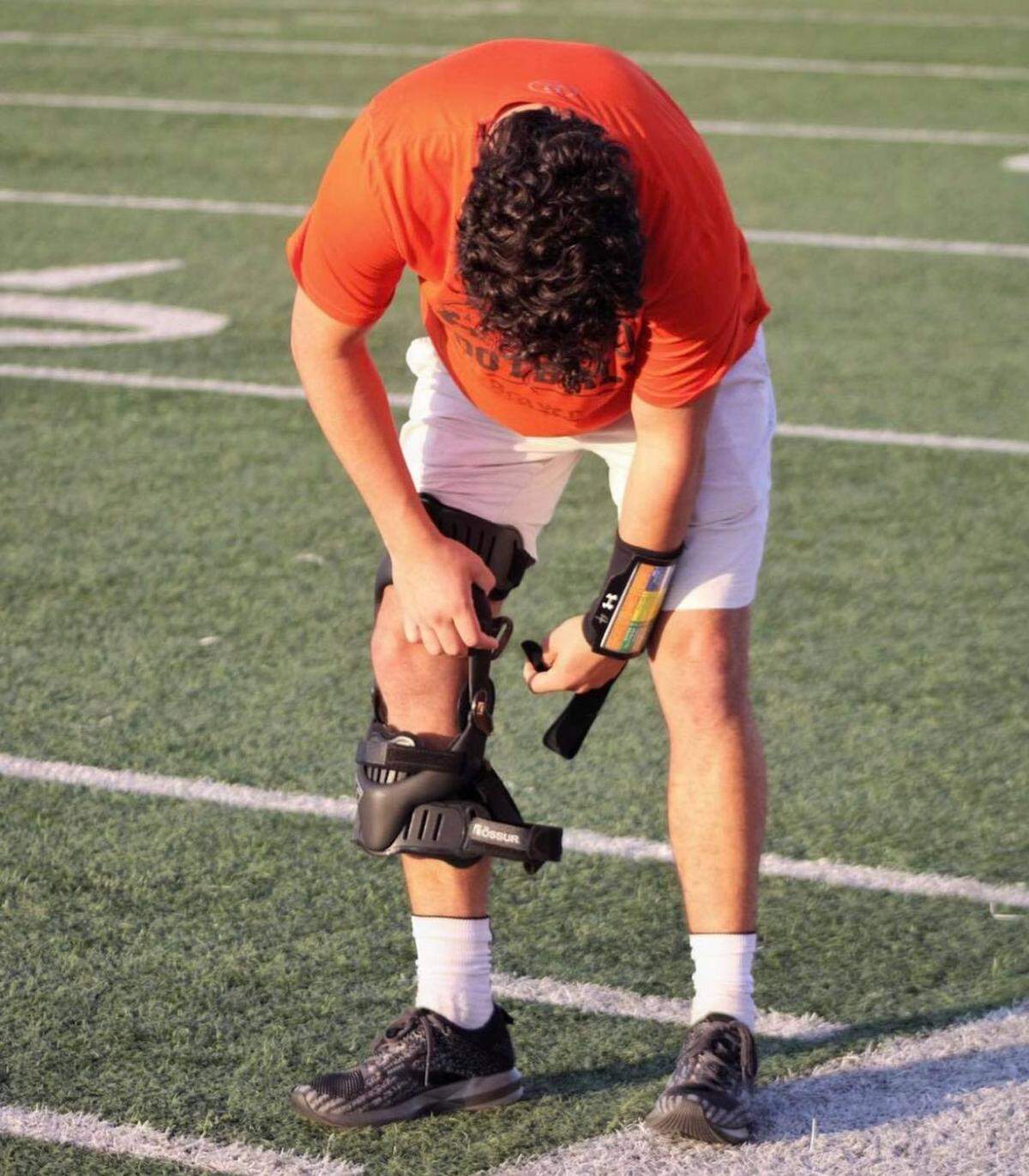 Aledo senior QB Ethan McBrayer puts on a knee brace during practice this season. McBrayer returned to the field just nine weeks after tearing his right ACL thanks to stem cell research.