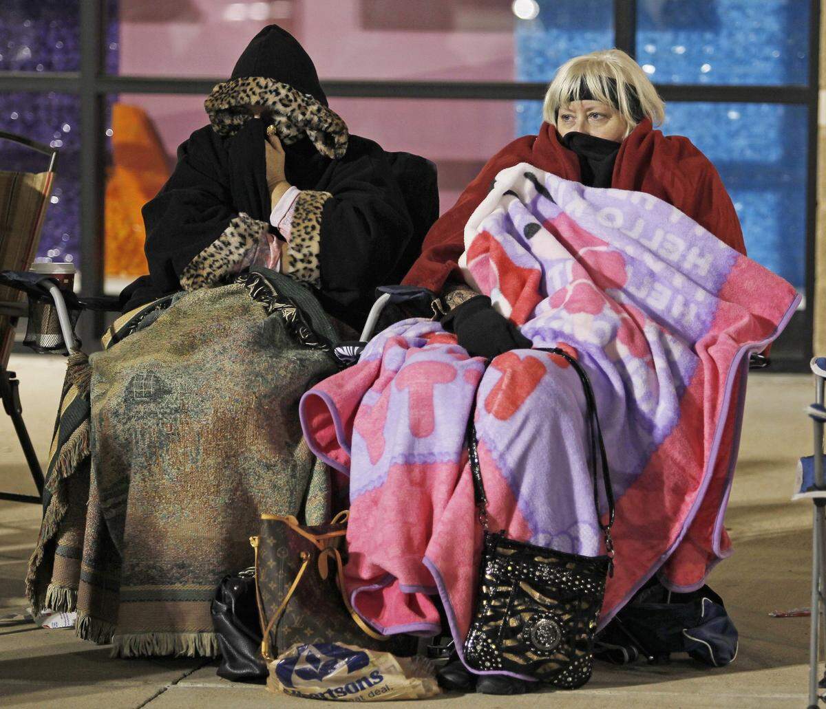 2011: Battling the evening chill in Hurst, Erin Carter of Roanoke and friend Delores Thurston of Jefferson City, Missouri, waited in the line for their daughters who went to shop at other stores.