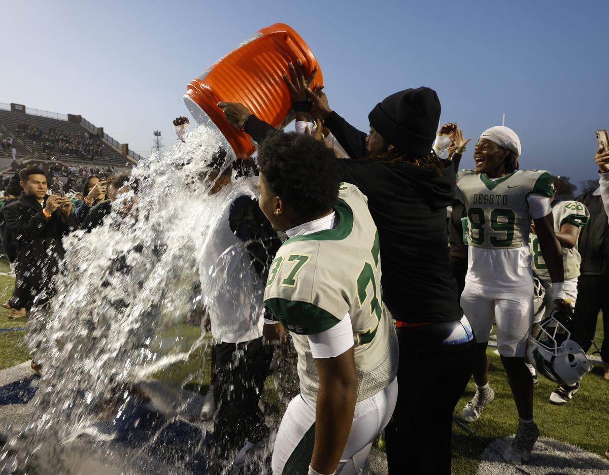 DeSoto head coach Claude Mathis gets an ice water shower after the Eagles defeated Southlake Carroll in a Class 6A Division II state semifinal Saturday at Newsom Stadium in Mansfield.