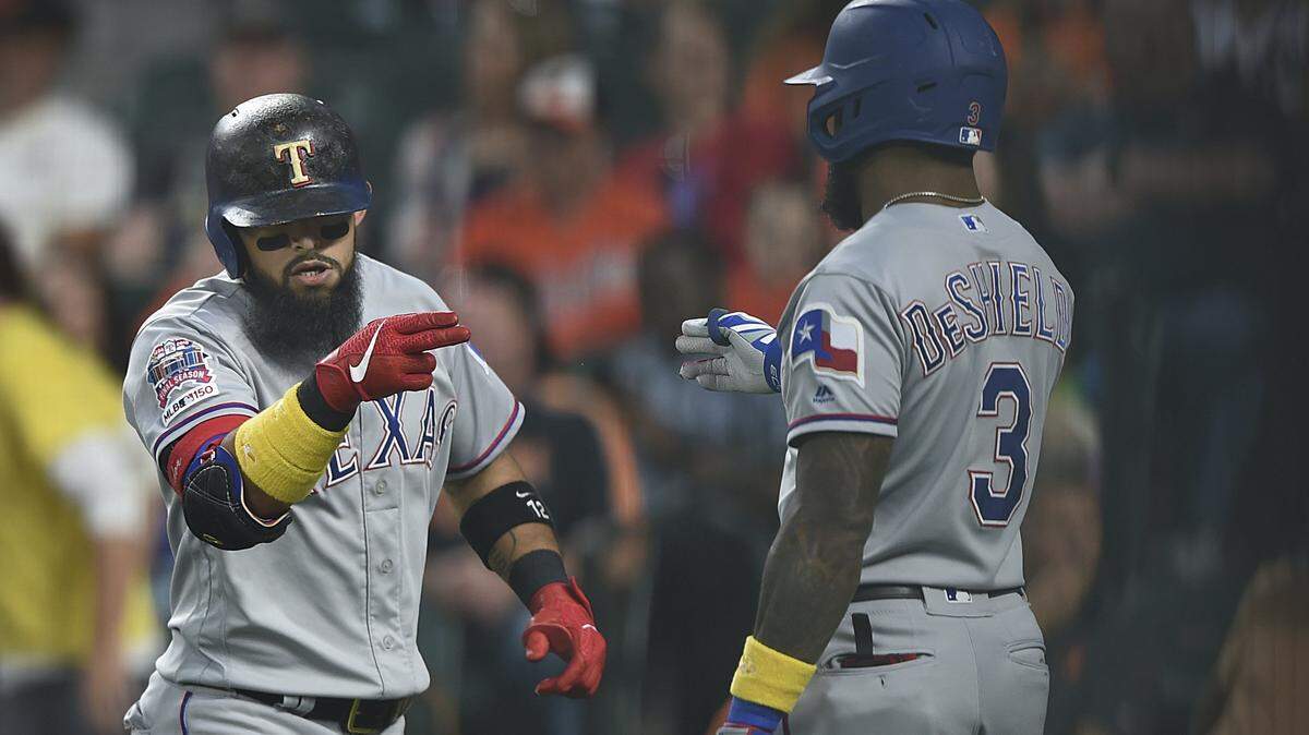 Delino DeShields greets Rougned Odor at home plate after Odor connected for a three-run homer in the first inning.